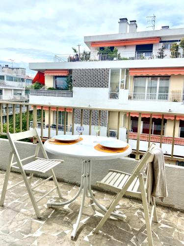 d'une table blanche et de deux chaises sur un balcon. dans l'établissement PWS Antibes, Provence-Alpes-Côte-d'azur, Studio, à Antibes