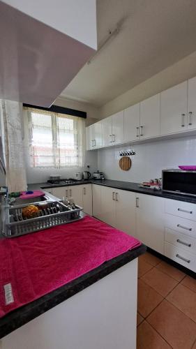 a large kitchen with white cabinets and a red rug at Hotel Mead Road - 2 bedroom Deluxe in Suva