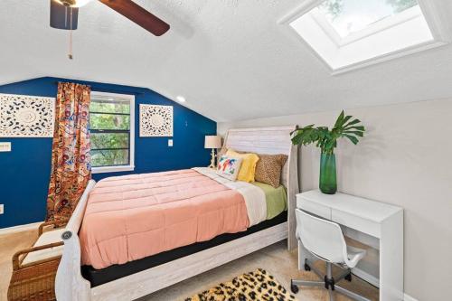 a bedroom with a bed and a blue wall at Zen Jungle House by Busch Gardens Sleeps 12 with Outdoor Games & Detached Play Space! in Tampa