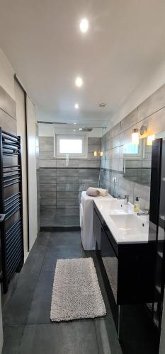 a bathroom with a sink and a bath tub at Appartement cosy in Richemont