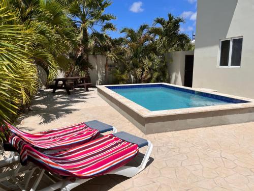 un par de sillones junto a una piscina en Andira Apartments, en Willemstad