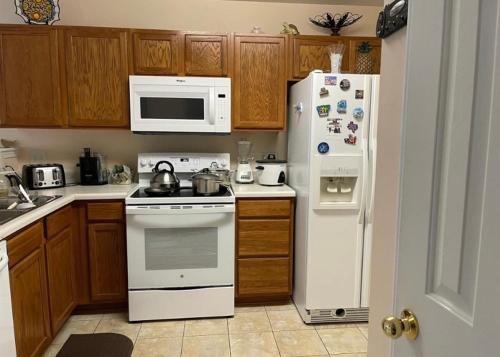 eine Küche mit weißen Geräten und Holzschränken in der Unterkunft Private Bed and Bath in Charlotte in Charlotte
