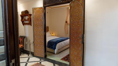 a mirror in a room with a bed at Dar Bouzoubaa in Fez