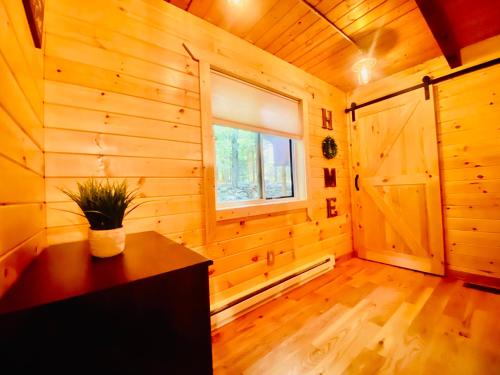 a room with wooden walls and a window and a wooden floor at Lakeview Cabin in The Hideout in Lake Ariel