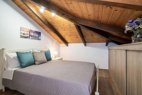 um quarto com uma cama num quarto com tectos em madeira em Villa Saliaj em Ambelókipoi