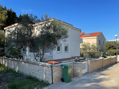 een huis met een steunmuur en een hek bij Apartments by the sea Susica, Ugljan - 21389 in Ugljan