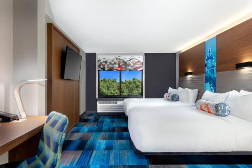 a hotel room with two beds and a desk at Aloft Columbia Harbison in Columbia