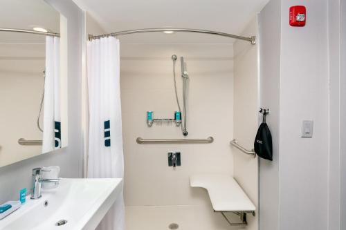 Aloft Columbia Harbison في كولومبيا: حمام أبيض مع حوض ودش