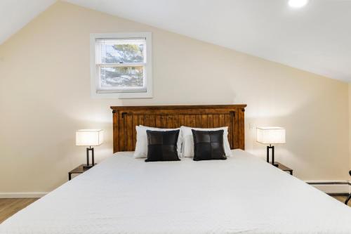 um quarto com uma grande cama branca e 2 candeeiros em Fantastic retreat 5min from Village w/ media room! em Stowe