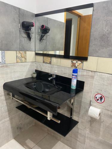 a bathroom with a black sink and a mirror at Santino Apart in Puerto Iguazú