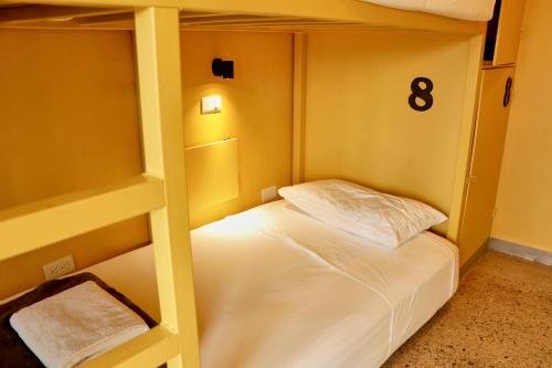 a bedroom with a bunk bed with white sheets at Casa Nomada Tuxtla Hotel - Hostal in Tuxtla Gutiérrez