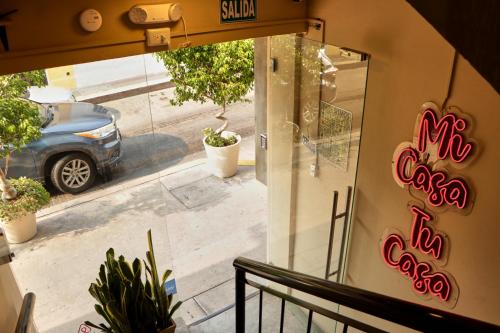 a window of a restaurant with a car in the street at Casa Nomada Tuxtla Hotel - Hostal in Tuxtla Gutiérrez