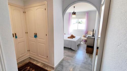 un couloir avec un miroir et une chambre avec un lit dans l'établissement 2BDR Penthouse, terrace, BBQ, pools and sea view in Benalmádena, à Benalmádena