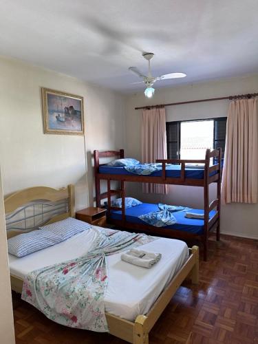 a bedroom with two bunk beds and a window at Hotel Bandeirantes de SJBV in São João da Boa Vista