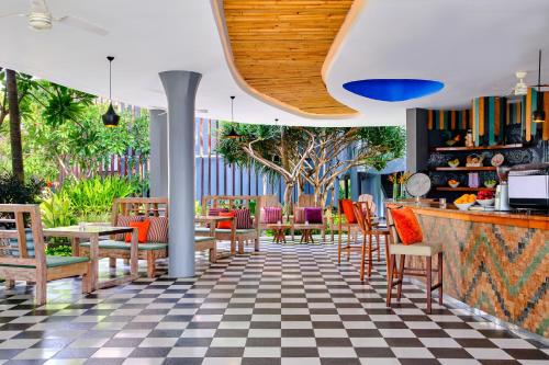 a restaurant with a checkered floor and tables and chairs at Le Meridien Bali Jimbaran in Jimbaran