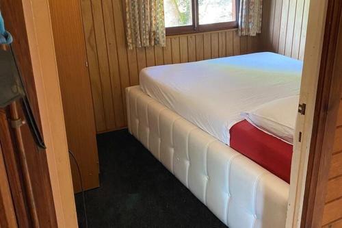 ein kleines Schlafzimmer mit einem weißen Bett und einem Fenster in der Unterkunft Ortho Hideaway with Garden in Bertogne
