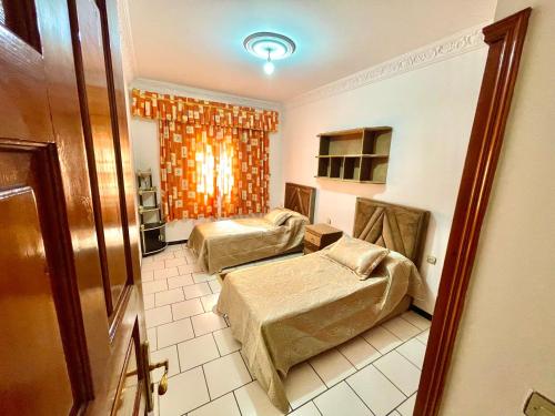 a hotel room with two beds and a window at Dar Rachid in Asilah