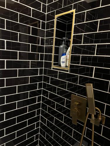 a bathroom with a black tiled wall with a mirror at Welcome to the AUC Modern Unit in Atlanta