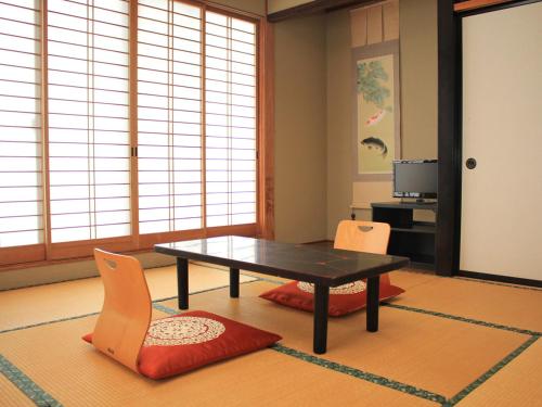 a living room with a table and two chairs at Hachibosi in Makinohara