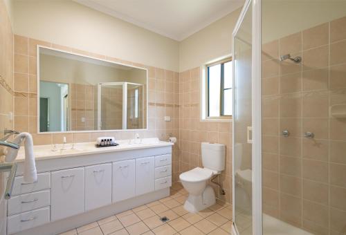 y baño con aseo, lavabo y ducha. en The Power House - Views & More en Airlie Beach