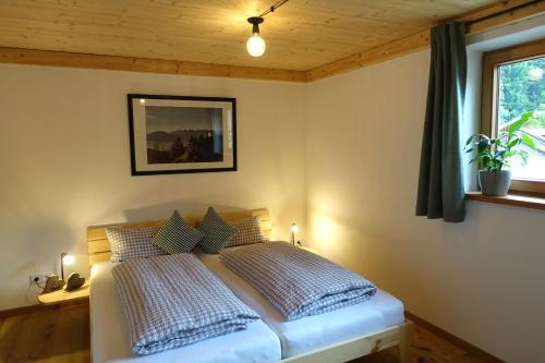 een slaapkamer met een bed in een kamer met een raam bij Bleierhof in Kiefersfelden