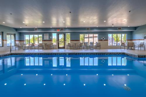 una piscina en un hotel con sillas y mesas en Holiday Inn Express Hotel & Suites Shelbyville, an IHG Hotel, en Shelbyville