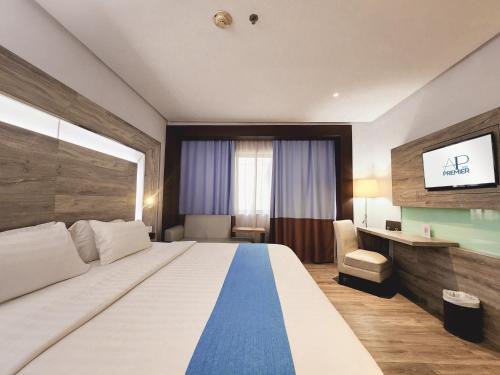 a hotel room with a large bed and a desk at AP Premier Batam in Nagoya