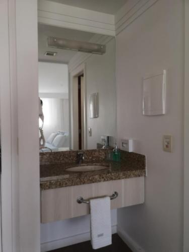 a bathroom with a sink and a mirror at Flat particular no Hotel Mercure in Brasília