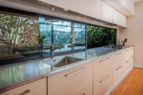 a kitchen with a sink and two large windows at Million Dollar View - Takamatua Holiday Home in Akaroa