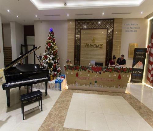 a christmas tree in front of a store with a piano at Vinhomes Central Park Apartment Landmark Căn hộ DV in Ho Chi Minh City