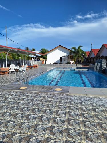 a swimming pool with a tile floor at The Nutshell Chalet Langkawi in Pantai Cenang