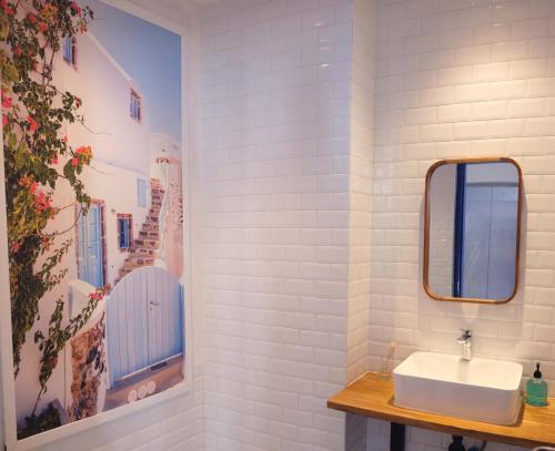 a white bathroom with a sink and a mirror at Little Mykonos in Bandung