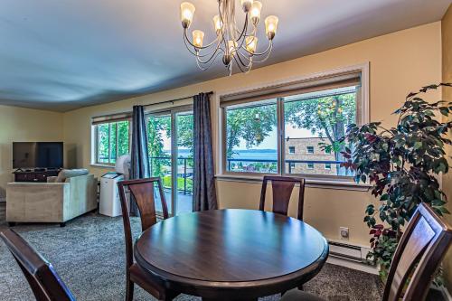una sala da pranzo con tavolo, sedie e finestre di Pacific View, Best Area, 2 Baths, 2 Bedrooms, WD, Jacuzzi Bath, New Carpet, Balcony, View, 925sf a Tacoma