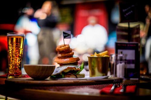 a sandwich on a table with a glass of beer at Sheraton Skyline Hotel London Heathrow in Hillingdon