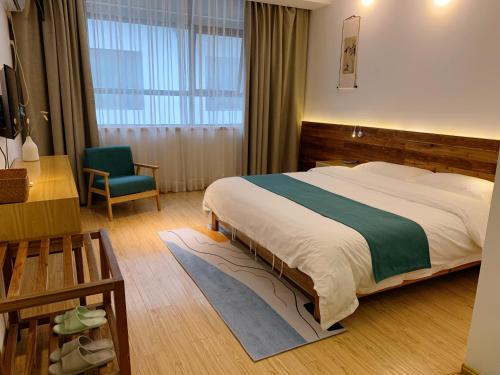 1 dormitorio con 1 cama grande y 1 silla en Sunny Homestay&One House en Zhangjiajie