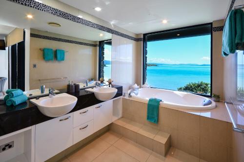 a bathroom with two sinks and a large window at Edge Waterfront Apartments in Hamilton Island