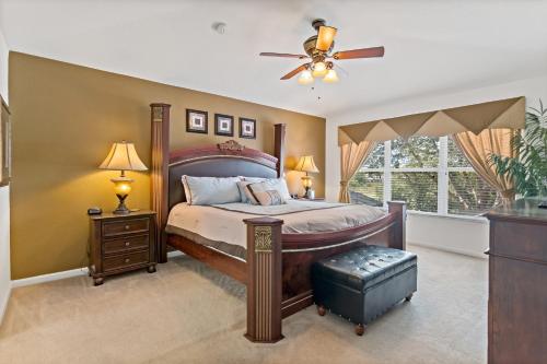 a bedroom with a large bed and a ceiling fan at The Pink House at Windsor Hills in Orlando