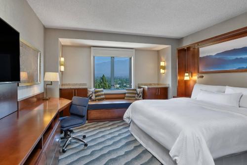 a hotel room with a bed and a desk and a television at The Westin Pasadena in Pasadena