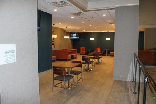 a waiting room with tables and chairs at Holiday Inn Baton Rouge-South by IHG in Baton Rouge