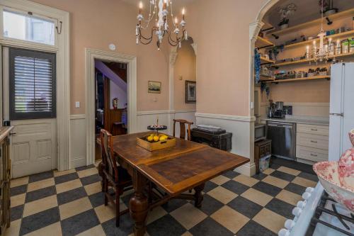 a dining room with a table and a kitchen at Pinc Lady Mansion in Eureka