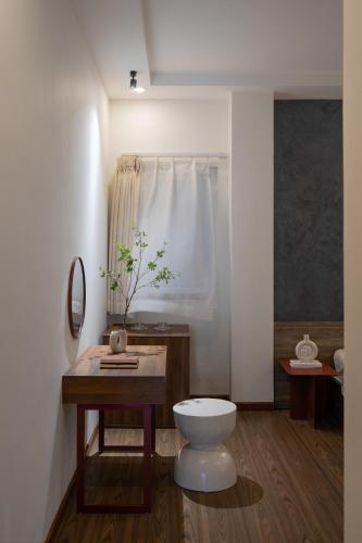 a bathroom with a toilet and a table and a mirror at Hồng Môn Resort Đà Lạt in Da Lat