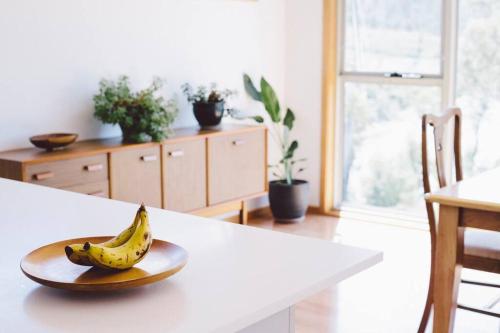 a banana on a plate on a counter in a kitchen at Modern Waterfront House at Susans Bay, Primrose in Primrose Sands