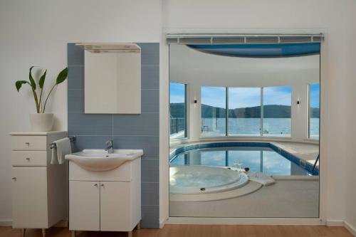 a bathroom with a tub with a view of the water at Villa Luxury Maja Zablace in Šibenik