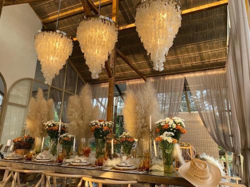 a long table with flowers in vases and chandeliers at 1000 Stars 
