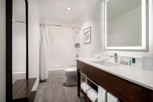 南舊金山的住宿－福朋喜來登酒店- 舊金山機場店，白色的浴室设有水槽和卫生间。