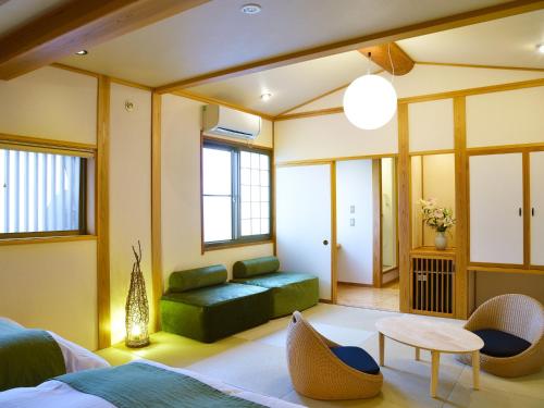 a living room with a green couch and a table at Ryokan Okayama in Akakura