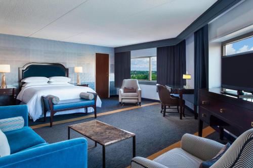 um quarto de hotel com uma cama e uma televisão de ecrã plano em Sheraton Syracuse University Hotel and Conference Center em Syracuse