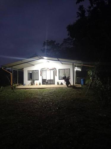 a small white house at night with the lights on at Casa de campo en La Vega, hermosa vista, con Internet y parqueadero in La Vega