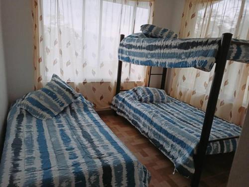 two bunk beds in a room with a window at Casa de campo en La Vega, hermosa vista, con Internet y parqueadero in La Vega