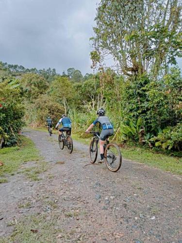 three people riding bikes down a dirt road at Casa de campo en La Vega, hermosa vista, con Internet y parqueadero in La Vega